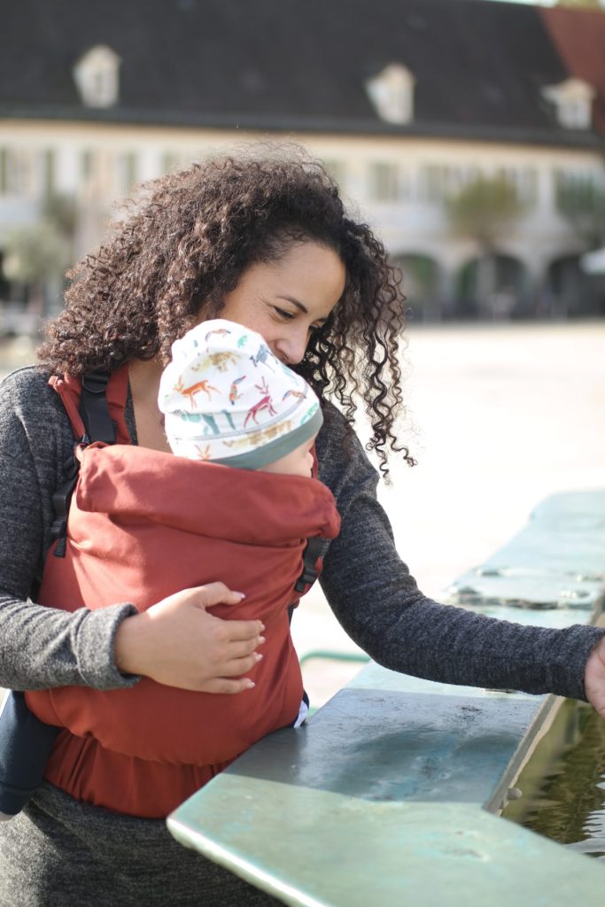 Woman wearing a brick-colored baby carrier