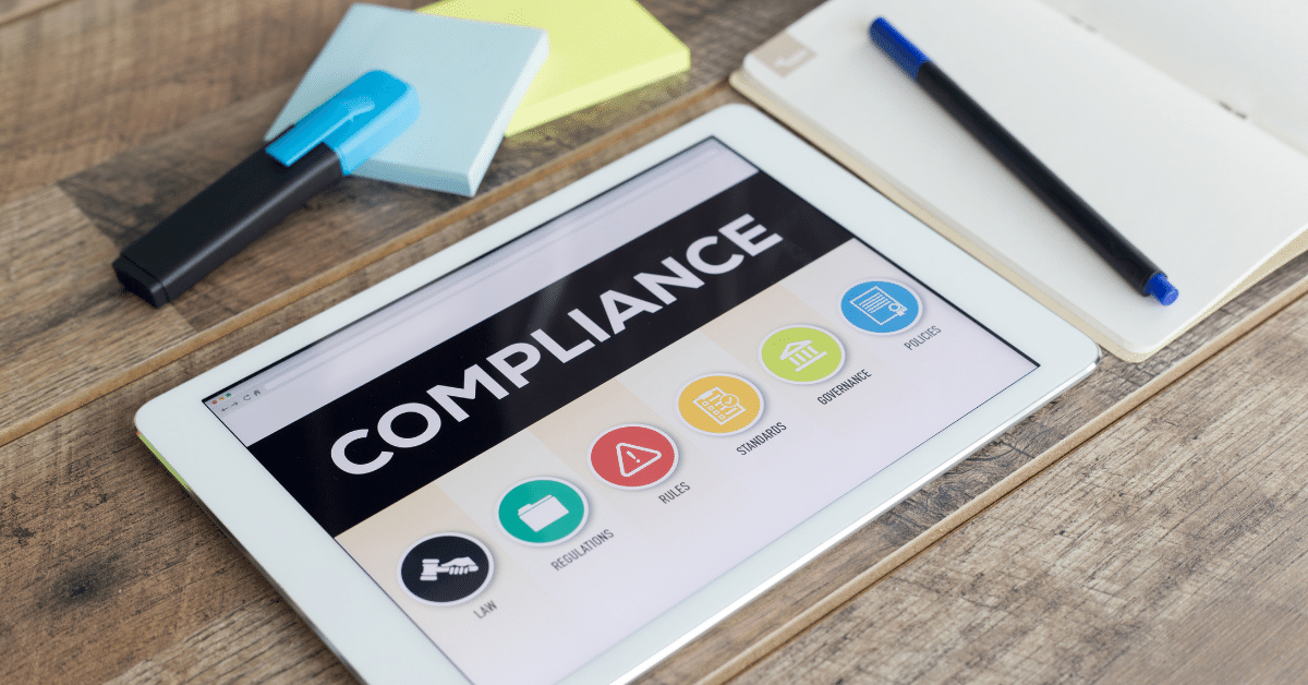 Tablet showing the word compliance - Annual-Compliance-Review-For-Babywearing-Businesses